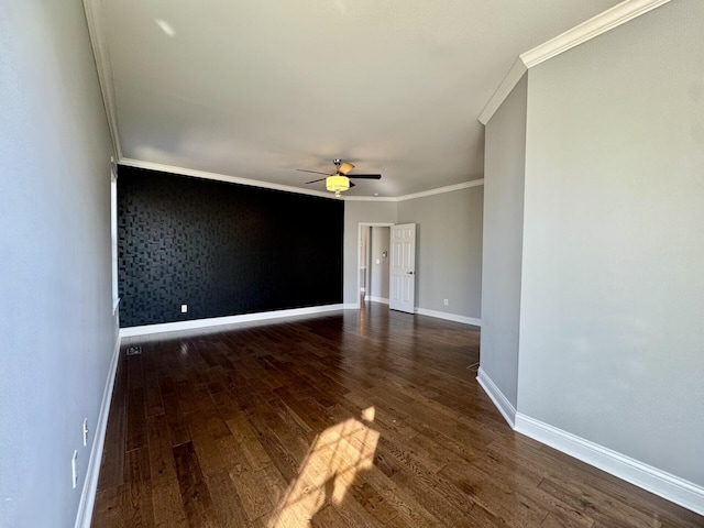 spare room with ceiling fan, wood finished floors, baseboards, and crown molding