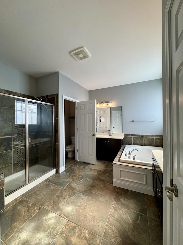 bathroom featuring a stall shower, toilet, vanity, and a garden tub