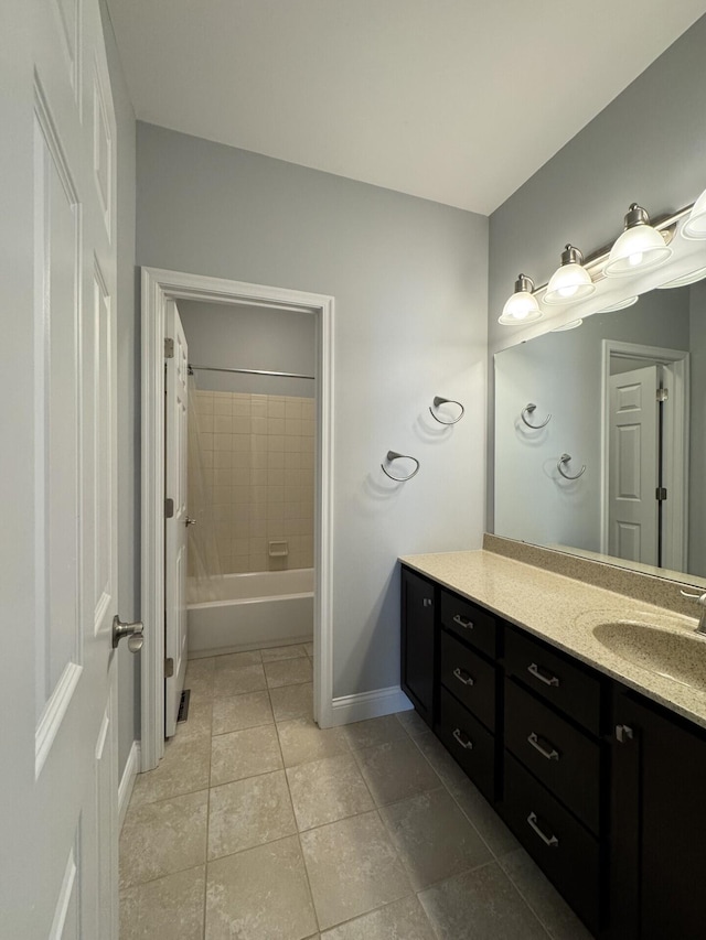 bathroom with vanity, baseboards, tile patterned floors, and washtub / shower combination