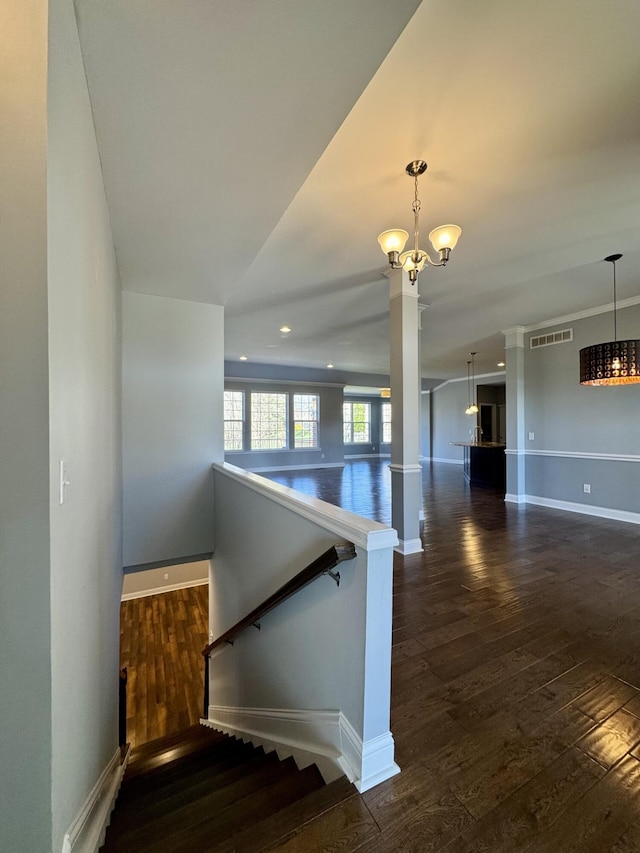 stairs featuring a chandelier, baseboards, and wood-type flooring