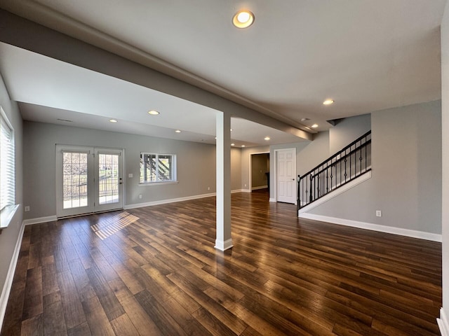 unfurnished living room with dark wood-type flooring, baseboards, stairs, and recessed lighting