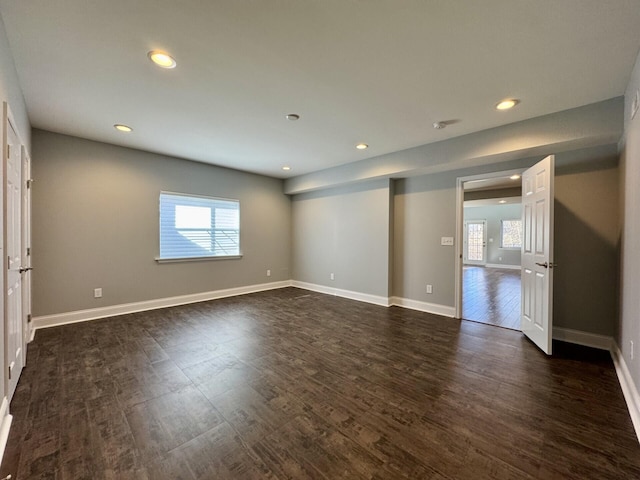 unfurnished room with plenty of natural light, dark wood-style floors, recessed lighting, and baseboards