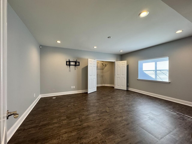 unfurnished bedroom featuring dark wood finished floors, recessed lighting, baseboards, and a closet