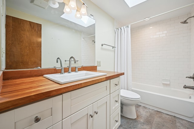 full bathroom featuring a skylight, toilet, shower / bath combination with curtain, and vanity