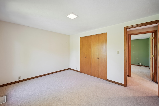 unfurnished bedroom featuring carpet floors, baseboards, and a closet