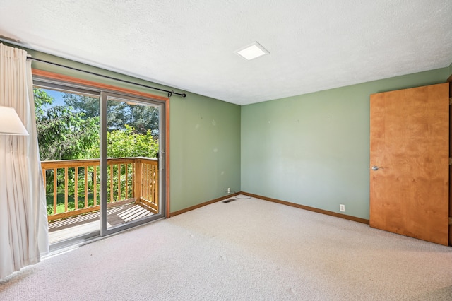 unfurnished room with carpet floors, baseboards, and a textured ceiling