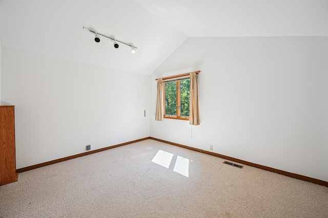 additional living space with vaulted ceiling, light carpet, and baseboards