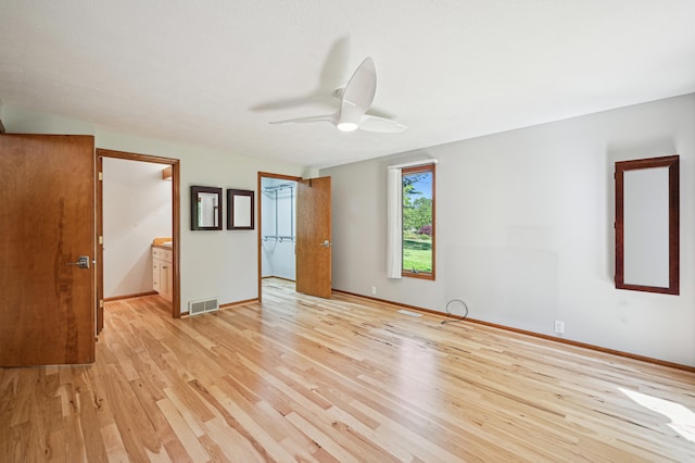 unfurnished room featuring ceiling fan, light wood finished floors, and baseboards