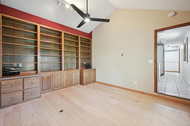 unfurnished office featuring light wood-type flooring, a ceiling fan, vaulted ceiling, and baseboards