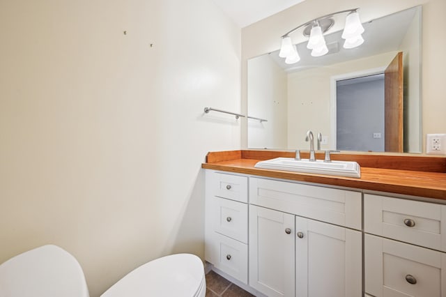 bathroom with toilet, vanity, and tile patterned floors