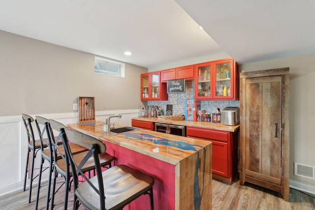 574 Ravensridge Ct, Alexandria, KY 41001 - indoor wet bar featuring light wood-style flooring, tasteful backsplash, beverage cooler, recessed lighting, and a wainscoted wall