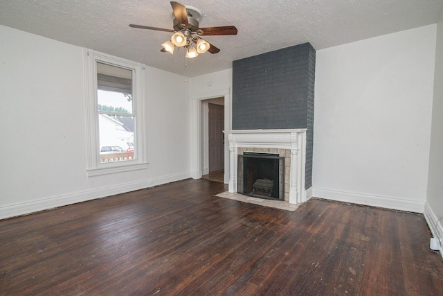 3213 Decoursey Ave, Covington, KY 41015 - unfurnished living room featuring wood-type flooring, ceiling fan, a tile fireplace, baseboards, and a textured ceiling