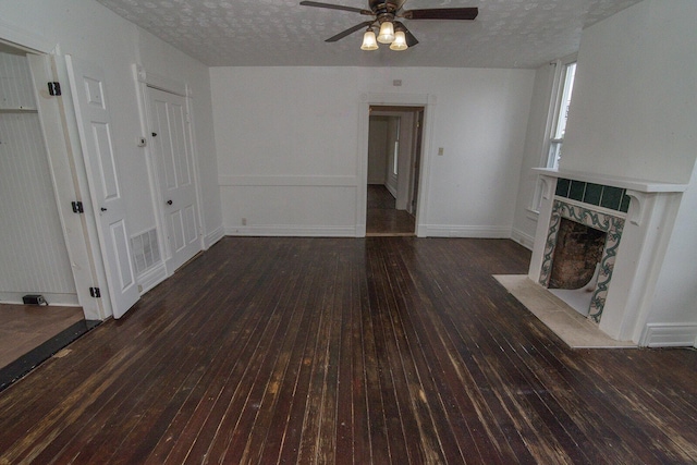 3213 Decoursey Ave, Covington, KY 41015 - unfurnished living room with hardwood / wood-style floors, a ceiling fan, a tiled fireplace, a textured ceiling, and baseboards