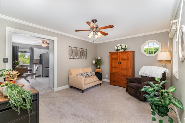 living room with a ceiling fan, crown molding, light carpet, and baseboards