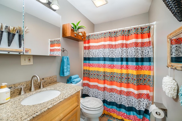 full bath featuring toilet, vanity, and a shower with curtain