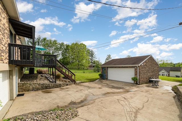 view of yard with stairs, an outdoor structure, a garage, and a wooden deck