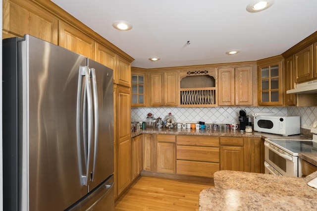 335 Fernwood Dr, Williamstown, KY 41097 - kitchen featuring white appliances, under cabinet range hood, brown cabinets, light wood-style flooring, and backsplash