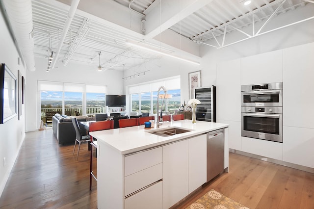 120 Main St Unit 306, Newport, KY 41071 - kitchen with a sink, stainless steel appliances, wine cooler, modern cabinets, and a breakfast bar area