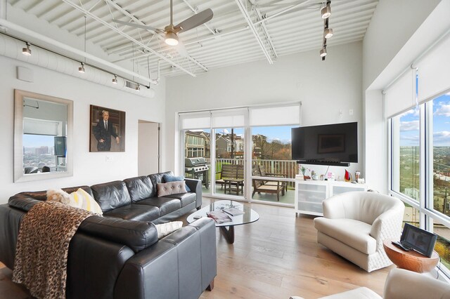 120 Main St Unit 306, Newport, KY 41071 - living room featuring rail lighting, ceiling fan, wood finished floors, and a high ceiling