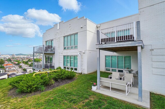 120 Main St Unit 306, Newport, KY 41071 - rear view of house featuring a balcony, a lawn, and brick siding