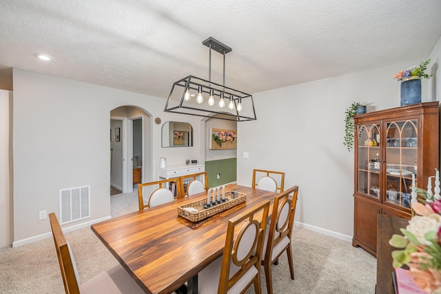 2263 Piazza Rdg, Covington, KY 41017 - dining area featuring light carpet, arched walkways, baseboards, and a textured ceiling