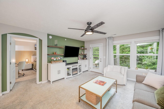 2263 Piazza Rdg, Covington, KY 41017 - living room with a ceiling fan, light colored carpet, baseboards, a textured ceiling, and a warm lit fireplace