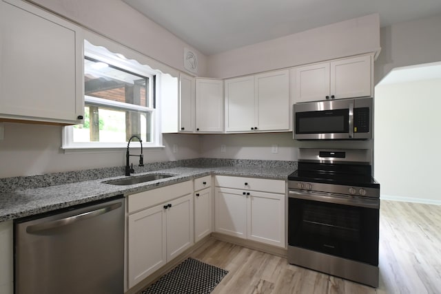 529 Stevenson Rd, Erlanger, KY 41018 - kitchen featuring stainless steel appliances, a sink, light wood finished floors, white cabinetry, and light stone countertops