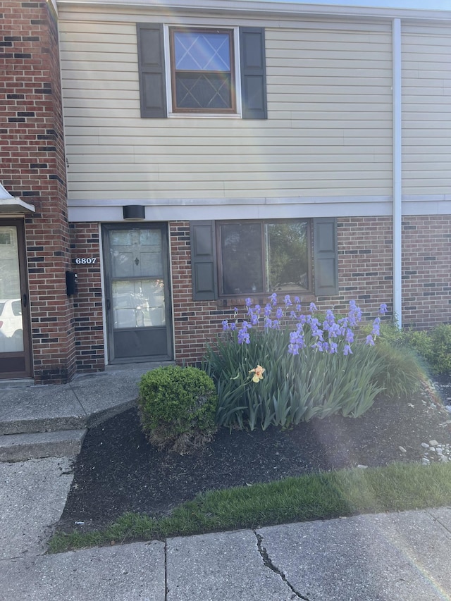view of exterior entry with brick siding