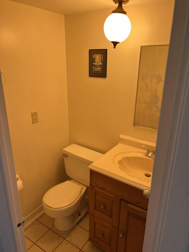 half bathroom with tile patterned floors, toilet, and vanity