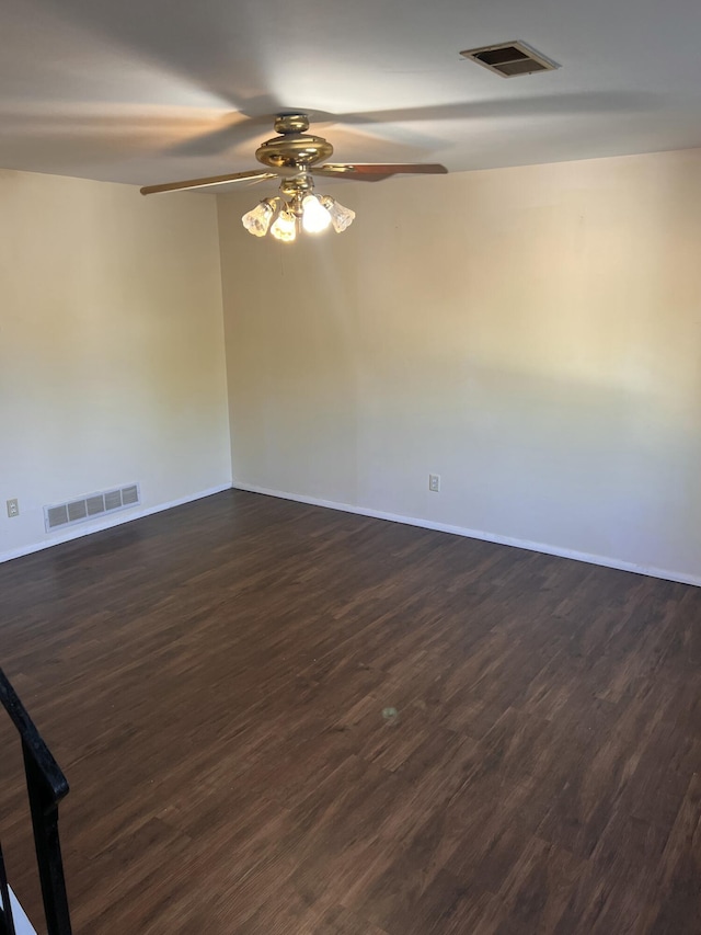 empty room featuring a ceiling fan, dark wood-style floors, and baseboards