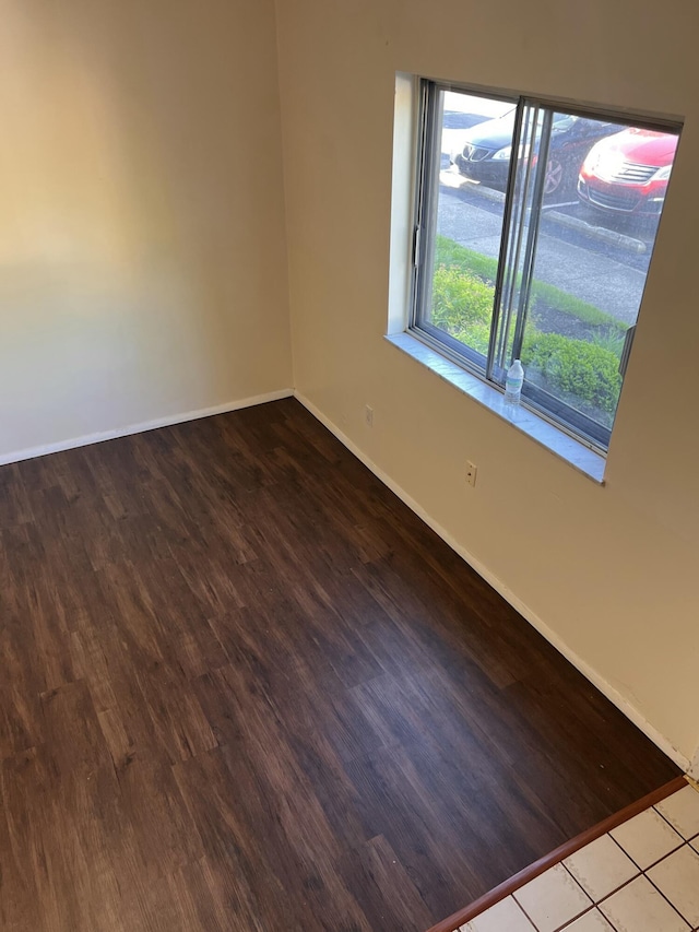 empty room featuring baseboards and wood finished floors
