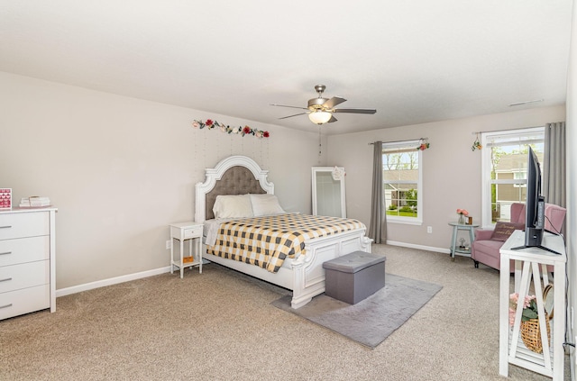 bedroom with light colored carpet, baseboards, and a ceiling fan