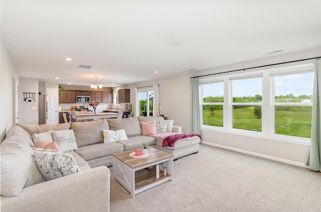 living area with a chandelier, recessed lighting, baseboards, and light colored carpet