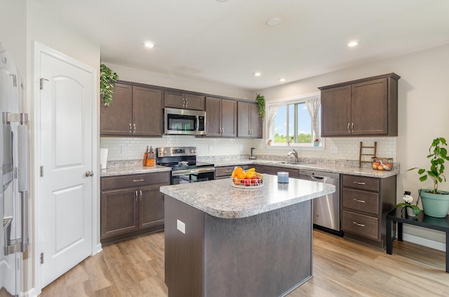 kitchen featuring appliances with stainless steel finishes, light wood-type flooring, dark brown cabinets, and recessed lighting