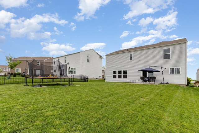 rear view of property featuring a trampoline and a patio