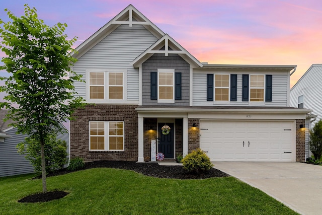 view of front facade featuring brick siding, driveway, a yard, and an attached garage