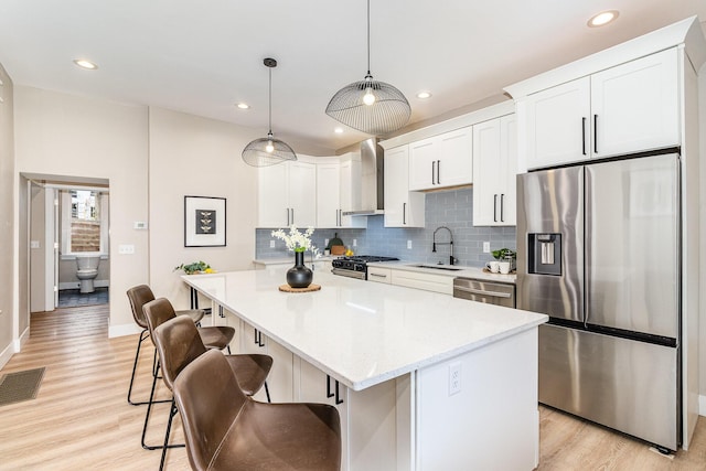 1102 Lee St, Covington, KY 41011 - kitchen with appliances with stainless steel finishes, wall chimney exhaust hood, a sink, backsplash, and baseboards