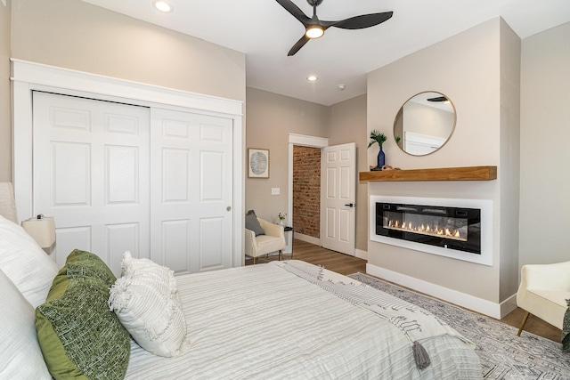 1102 Lee St, Covington, KY 41011 - bedroom featuring a glass covered fireplace, a closet, baseboards, wood finished floors, and recessed lighting