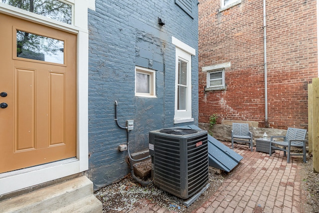 1102 Lee St, Covington, KY 41011 - property entrance with central AC unit, a patio area, and brick siding