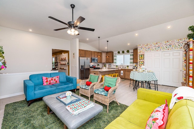 living area with light wood-type flooring, a ceiling fan, lofted ceiling, baseboards, and recessed lighting