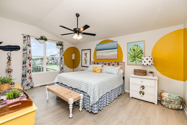 bedroom featuring wood finished floors, vaulted ceiling, baseboards, and a ceiling fan