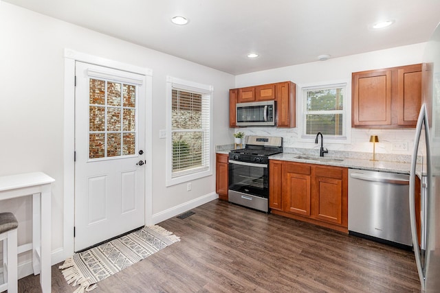 810 Saratoga St, Newport, KY 41071 - kitchen featuring a sink, appliances with stainless steel finishes, dark wood finished floors, brown cabinets, and light stone countertops