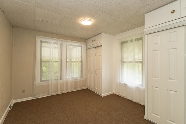 1101 Mckinney Ave, Dayton, KY 41074 - unfurnished bedroom featuring dark carpet, baseboards, and a drop ceiling