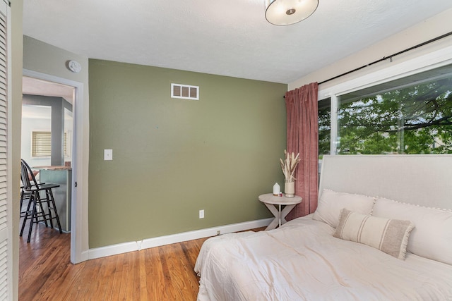 bedroom featuring baseboards and wood finished floors