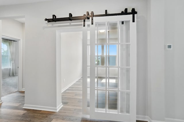 8042 Arcadia Blvd, Alexandria, KY 41001 - unfurnished room with healthy amount of natural light, wood finished floors, a barn door, and baseboards