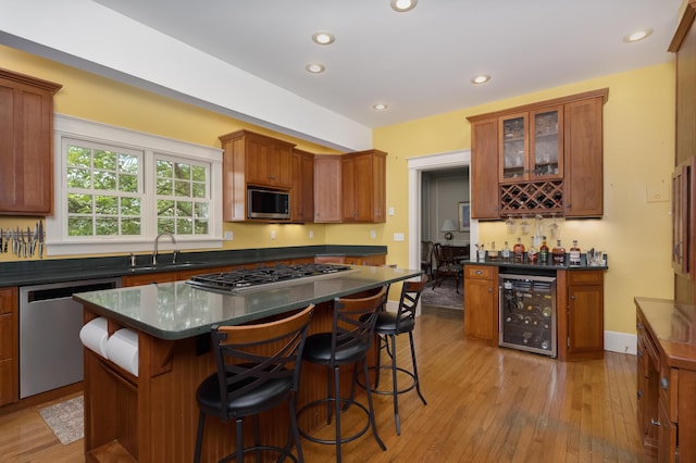 69 Linden Ave, Fort Thomas, KY 41075 - kitchen featuring appliances with stainless steel finishes, wine cooler, a sink, dark countertops, and light wood-style flooring