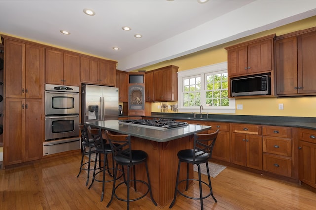 69 Linden Ave, Fort Thomas, KY 41075 - kitchen with a warming drawer, stainless steel appliances, a sink, a kitchen bar, and brown cabinets