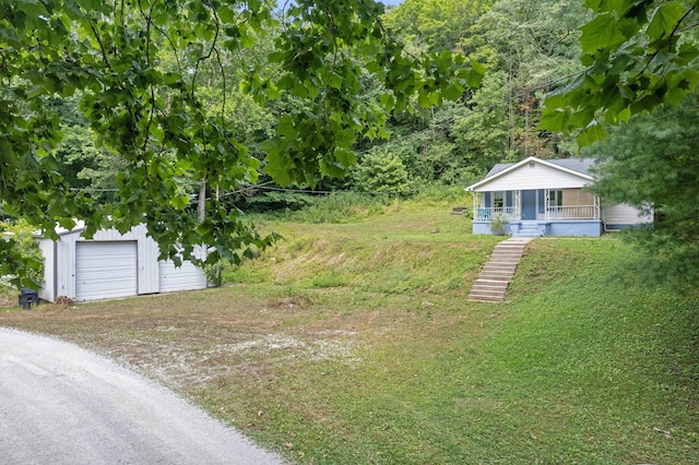 view of yard with an outbuilding, dirt driveway, and a porch