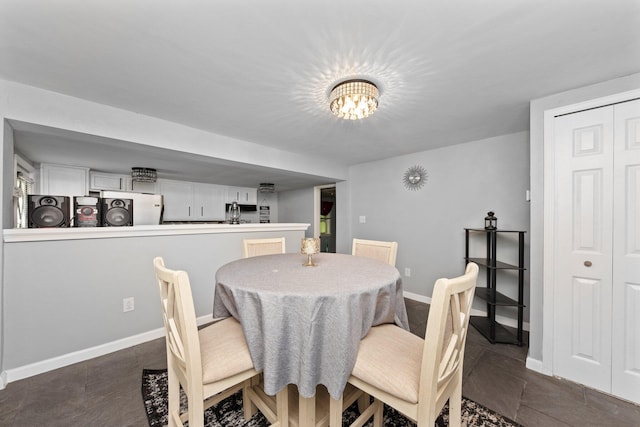 dining space with baseboards, a chandelier, and washer / clothes dryer