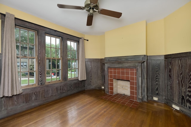 32 S Shaw Ln, Fort Thomas, KY 41075 - unfurnished living room with wainscoting, a tiled fireplace, wood finished floors, and a ceiling fan
